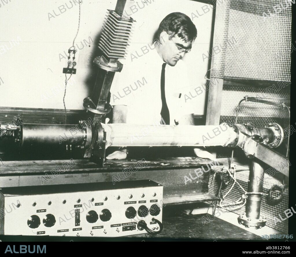 William Webster Hansen, (1909-1949), Ameican physicist who was one of the founders of the technology of microwave electronics. Here he is seen with a section of his first linear election accelerator, which operated at Stanford University, California, in 1947. It was eventually 3.6 meters long and could accelerate electrons to an energy of 6 MeV. He died at age 39 of a lung disease caused by inhaling the beryllium used in his research.