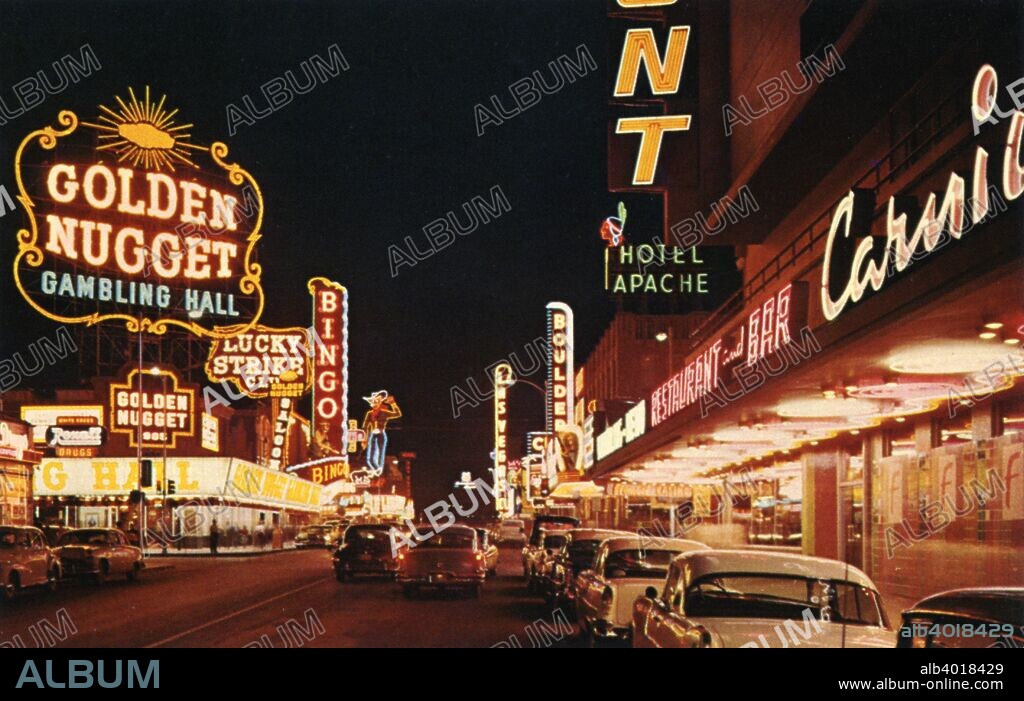 Fremont Street from Second Street, Las Vegas, Nevada, USA, 1956. Vintage postcard night view showing the various clubs, casinos and hotels on Fremont Street. Vintage automobiles travel the street. Neon signs light up the street.