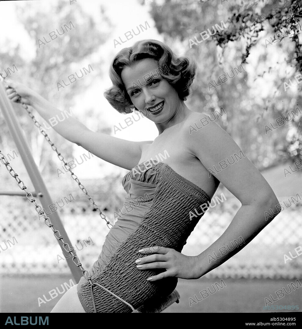 NOREEN NASH. Circa 1950, Hollywood, California, USA: 1940's American actress and model NOREEN NASH on a swing in the garden.