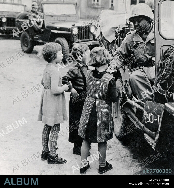 Geschichte /. Deutschland / Bundesrepublik:. Herbstmanöver "Cordon Bleu der US- Besatzungstruppen in Dinkelsbühl: Ein US-Soldat in einem Jeep schenkt deutschen Kindern Süßigkeiten. Foto, 17.10.1955.