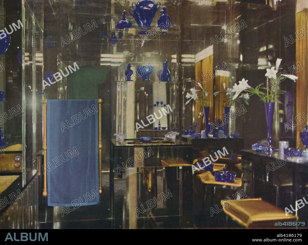 'The bathroom at Gayfere House, London, England, by Lady Mount Temple and Oliver Hill, F.R.I.B.A.', 1936. Walls and ceiling in mirror-glass by the London Sand Blast Decorative Glass Co, floor of Belgian black marble, bath and wash basin lined with gold mosaic, stool has gold-sprayed satin cushion. Venetian, English, Irish and Czechoslovakian glass ornaments, with Lalique glass motor-mascots used for the taps. From Decorative Art 1936 - Year-Book of The Studio, by C.G. Holme. [The Studio Limited, London, 1936].
