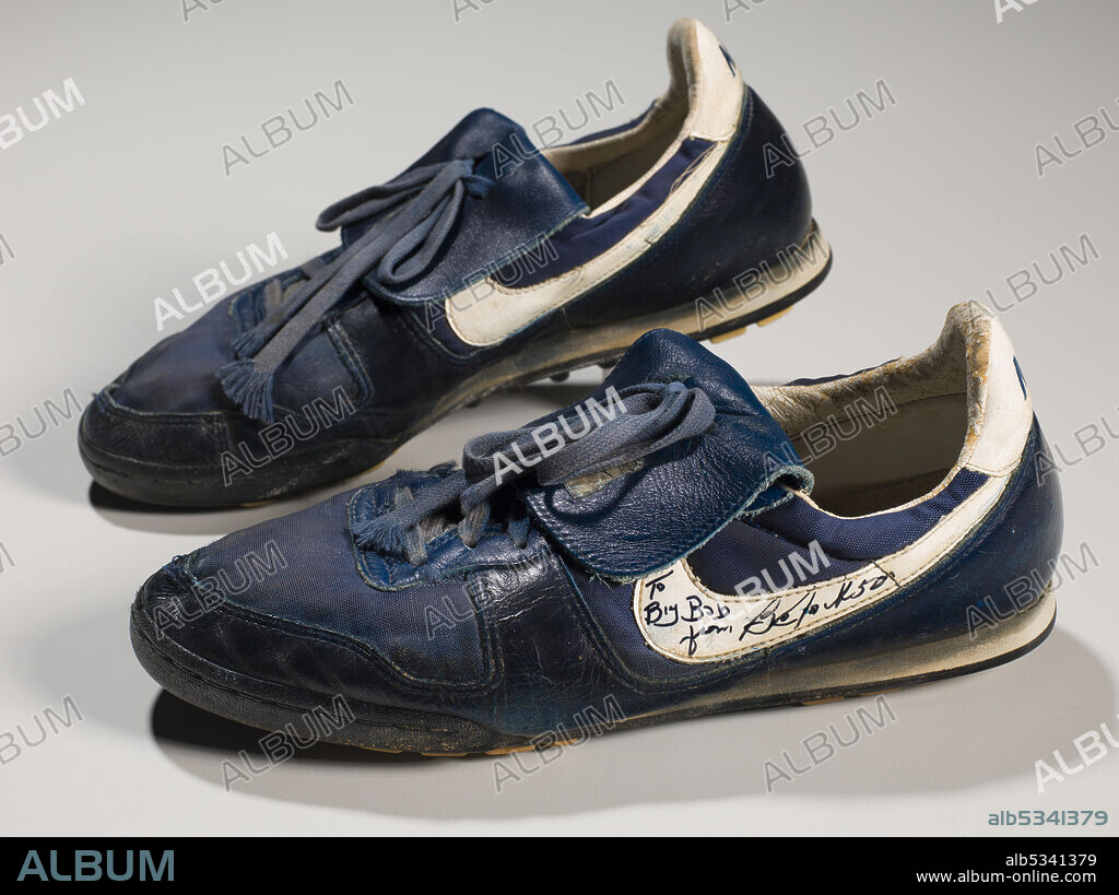 Pair of dark blue Nike athletic shoes worn by African-American professional baseball and football player Bo Jackson (born 1962). The shoes have white accents including a white Nike logo on the side of the shoes. Blue type on the back of the shoes reads: [NIKE]. Handwritten on each of the shoe's heels is: [BO]. An inscription in black marker on the outside of the left shoe's logo reads: [To / Big Bob / from, Bo Jackson]. The leather is extremely worn and cracking throughout.