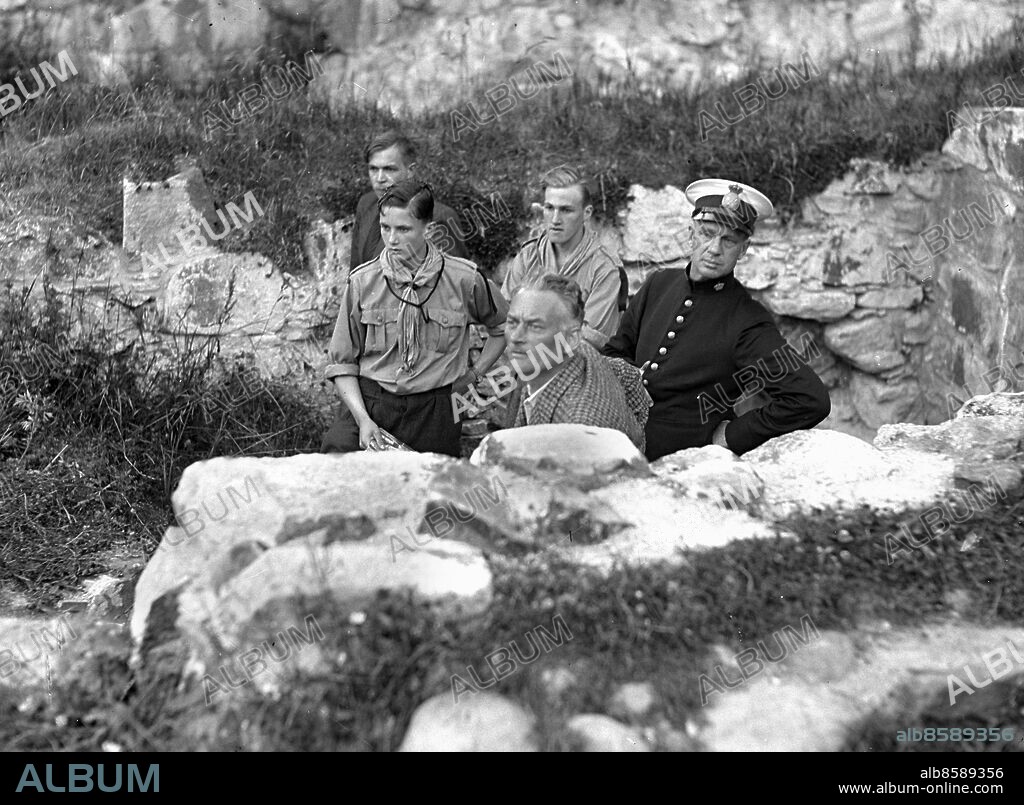 KUNGÄLV 1937-07-06.. Festspel på Bohus fästning - scouter, en polisman och regissören Knut Ström gömmer sig bakom en stenmur. *** Local Caption *** GT Låda 1937-juli-02 Foto: Kamerareportage / TT / Kod: 2524.