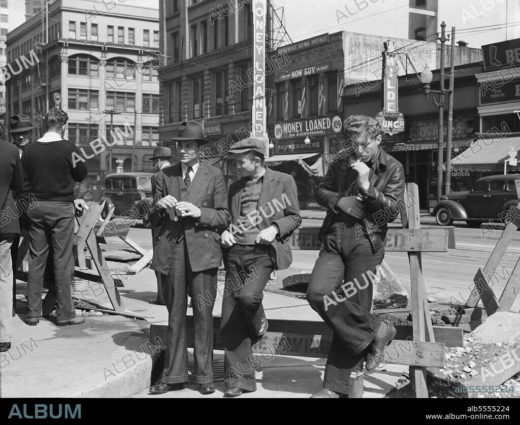 DOROTHEA LANGE. Salvation Army, San Francisco, California. Unemployed young men pause a moment to loiter and watch, and then pass on. [Signs: 'Money Loaned on Everything; Pawnbrokers'].