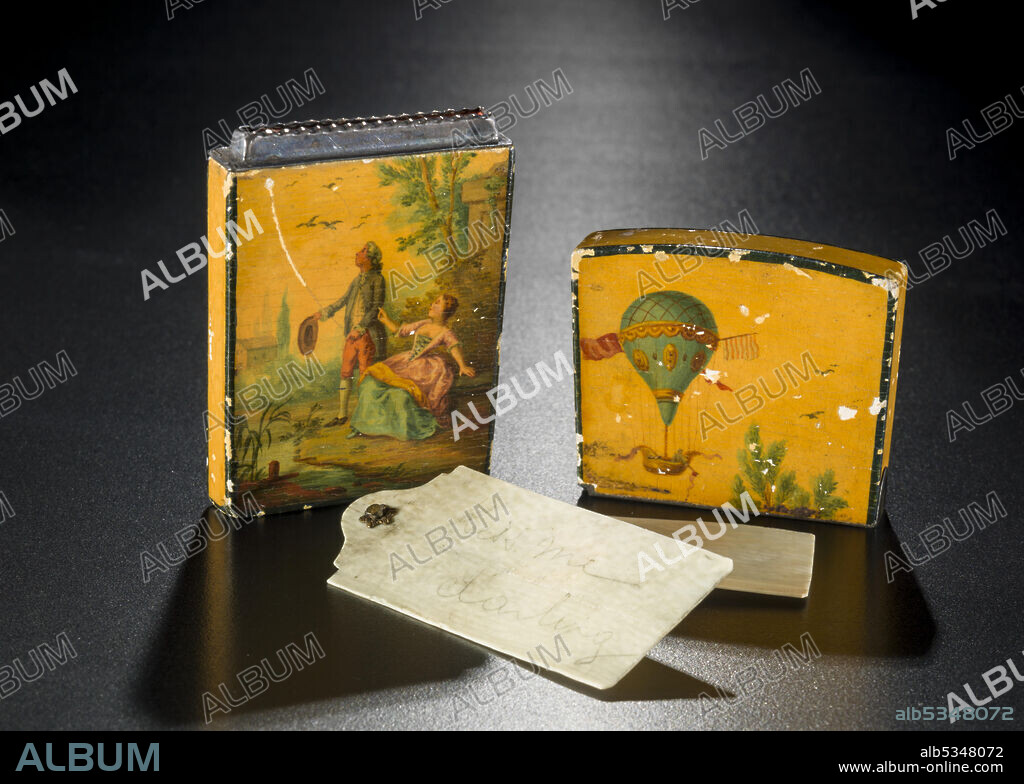 Dance card case and ivory cards, late 18th century. 'Carnets de bal' or dance cards were used at formal balls by ladies to record the names of the gentlemen with whom they intended to dance. The first successful flights in hot air balloons in the 1780s triggered a craze for 'ballooniana'. Exterior of wood case is painted with ballooning scenes. One side shows a man and woman looking up at a balloon in the sky. Case originally had a hinged lid. Edges of base and lid of case are lined in silver where they meet. Only two cards are currently present, but originally there were more and they were hinged like a fan. One of the cards has 'kiss me darling' handwritten in pencil on the surface.