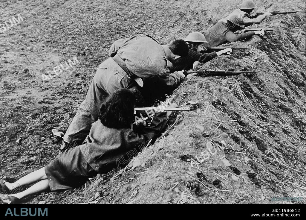 "Cyprus women soldiers. Cyprus business girls do a lunchtime shooting course near Nicosia. A battledress clad soldier of the Greek-Cypriot "Cyprus Army" gives shooting instruction to women volunteers. Half-uniformed girl nearest camera is going to get a burnt hand gun like that.". [defence, army, civilian, women, guns, helmets, funny]. 24 February 1964.