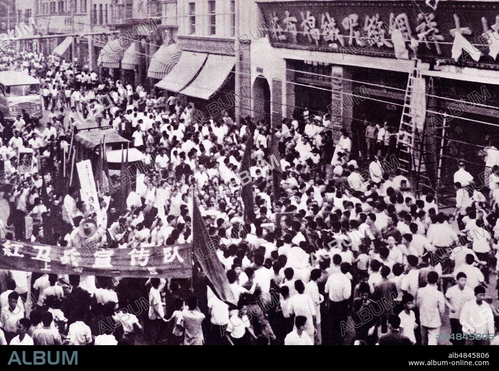 During the Cultural Revolution, in China, red guards dismantle old store name on Nanjing Road 3 in Shanghai and replaced it with a new one. 1967.