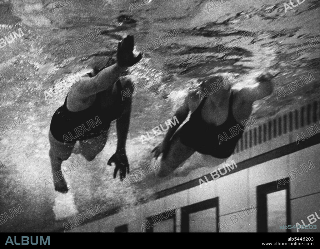 Under water picture taken through the observation panels at Loughborough College, Leicester, showing Fearne Ewart (16) of St. Leonards the 100 yards Junior Free Style Champion and Valerie Nares-Pillow of Kingston on Thames the Junior 220 yards Free Style Champion. April 16, 1953. (Photo by Daily Mirror).