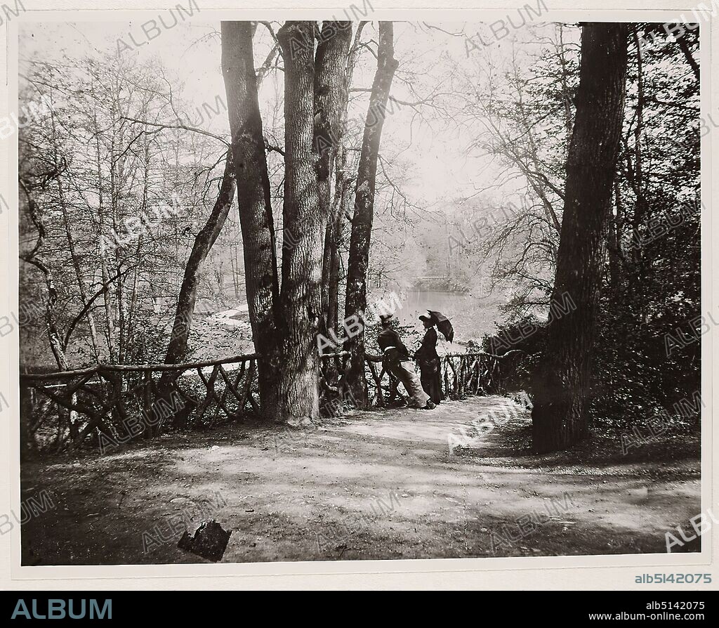 Louis Held, Im Weimarer Park, ca. 1885, Staatliche Landesbildstelle Hamburg, collection on the history of photography, silver gelatine paper, black and white positive process, image size: height: 11.50 cm; width: 14.60 cm, inscribed: verso and on the cardboard: Photographer, place, designation, dimensions and inv.- No. handwritten in black, Stamp: verso and left on the cardboard: Stamp of the Hamburg State Photographic Office, landscape photography, fashion, gardens and parks, man, woman, fence, wall, palisade, lake, trees, bushes, parasol, Weimar.