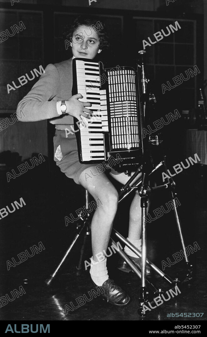 "No Hands" Italian Boy Accordionist Uses New Device - Famous young Italian accordion player Davide Anzaglie, he was third in the world championships, is seen playing an accordion held by the newly introduced stand which eliminates straps, at today's International Accordion Festival, at St. Pancras Town Hall, London.
Device may bring accordions into full orchestra use. November 5, 1949. (Photo by Fox Photos).