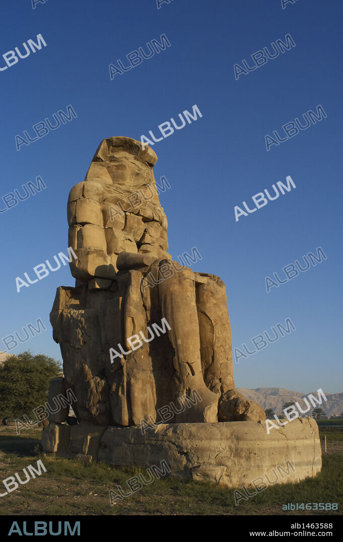 ARTE EGIPCIO. EGIPTO. COLOSOS DE MEMNON. Gigantescas esculturas que flanqueaban la entrada al templo funerario de Amenofis III, construido por el hijo de Haper, el arquitecto Amenofis. Tienen una altura de 16,6 m. Los dos representan al rey Amenofis III. Vista de una de las dos esculturas. MEDINET HABU. TEBAS. Egipto.