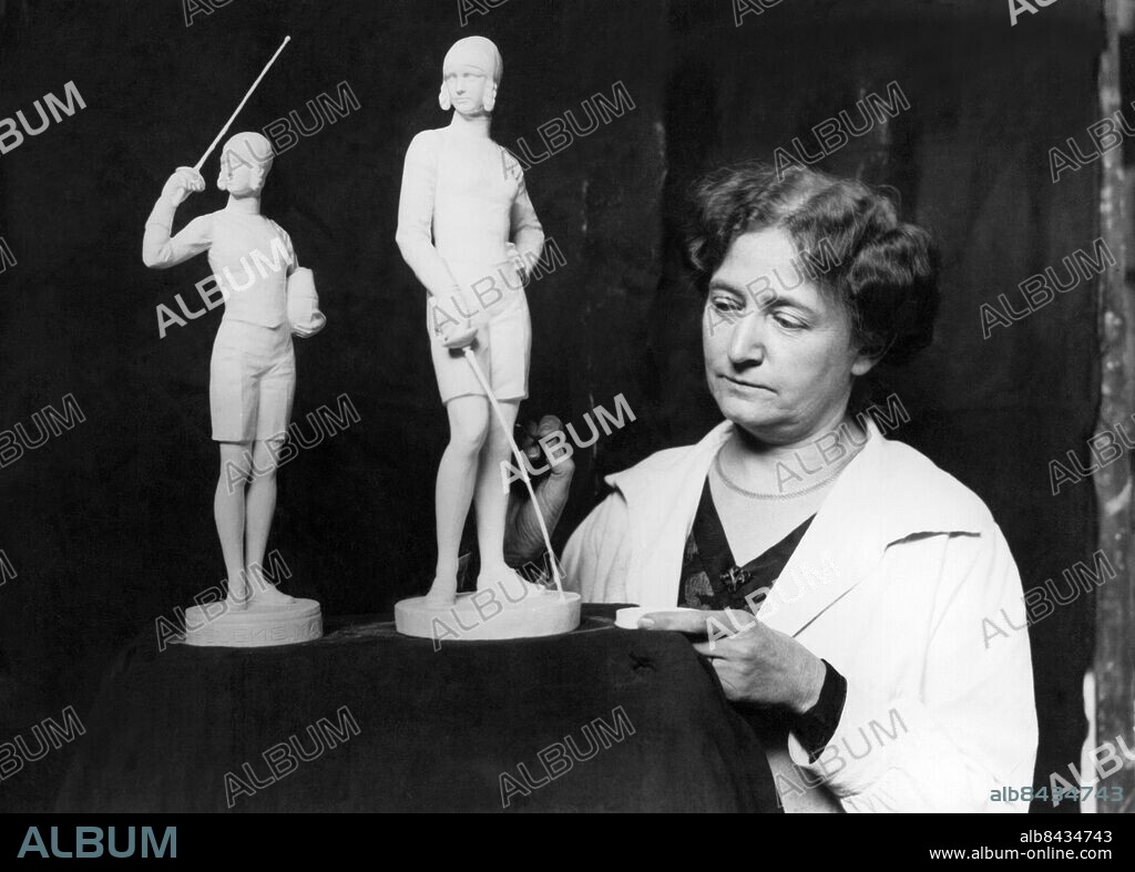 Orig. bildspråk... HELENE MAYER ALS DENKMAL. Die Berliner Bildhauerin Lilly Wislicenus-Finzelberg hat eine gelungene Statuette der deutschen Fechtmeisterin fertiggestellt. Unser Bild zeigt die Bildhauerin Lilly Wislicenus-Finzelberg bei der Arbeit an der Statuette von Helene Mayer. Anm. Wislicenus-Finzelberg, Lilly, 1877-1939, tysk skulptris Statyetter Fäktare CD399 persons: HELENE MAYER*;LILLY WISLICENUS-FINKELBERG sites: TYSKLAND;BERLIN.