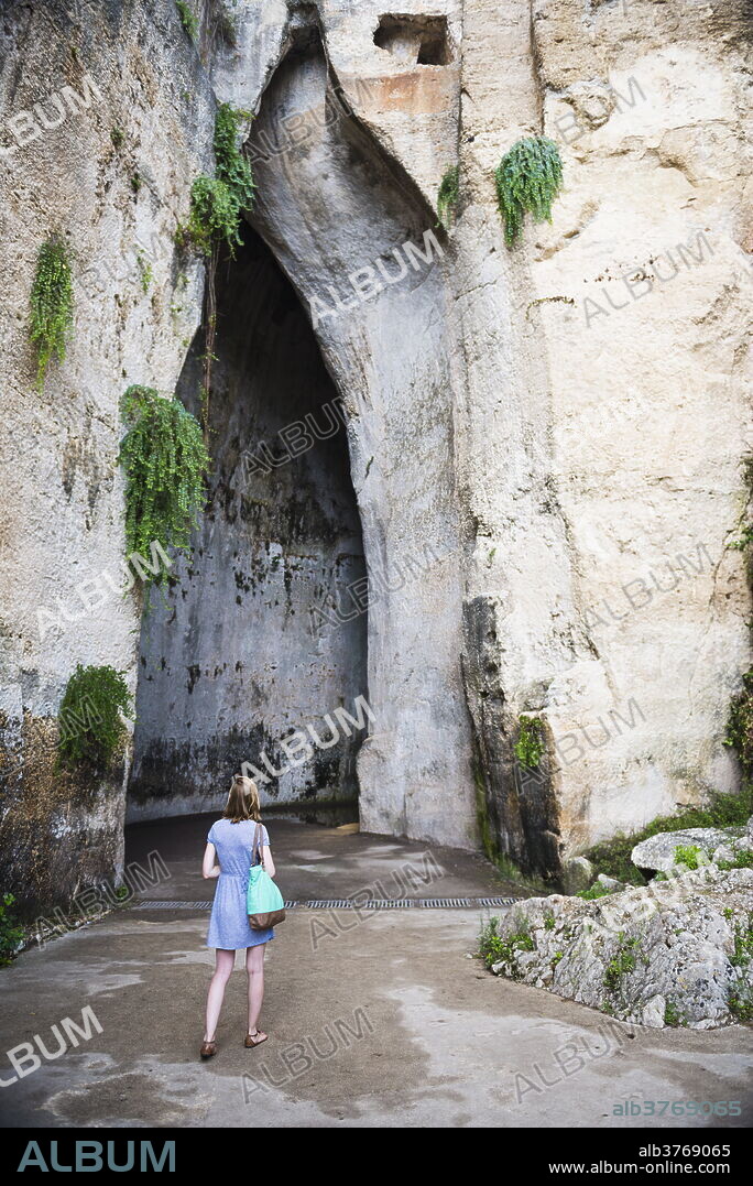 Tourist in a cave at the Quarry Garden, Archaeological Park of Syracuse, UNESCO World Heritage Site, Sicily, Italy, Europe.