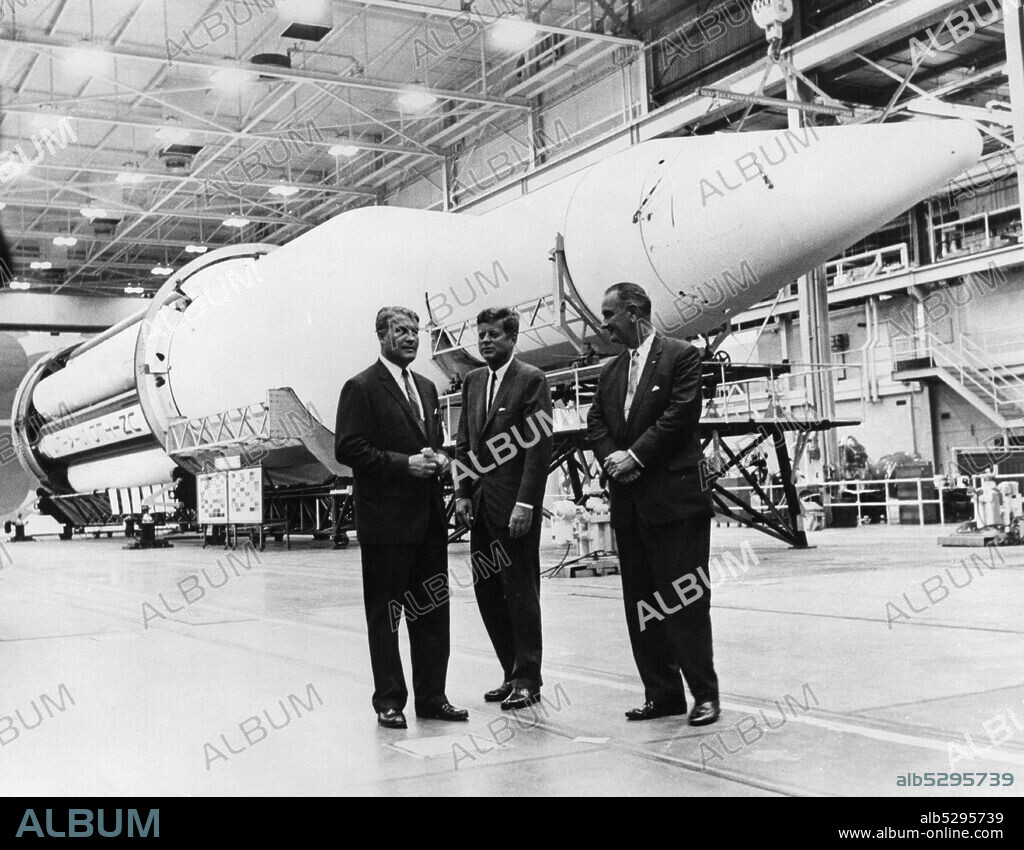 Wernher von Braun (1912-1977), ingeniero y mecánico aeroespacial estadounidense de origen alemán, junto al presidente John Fitzgerald Kennedy (1917-1963)  y el vicepresidente Lyndon Baines Johnson (1908-1973) en las instalaciones de la NASA ante el cohete Saturno.