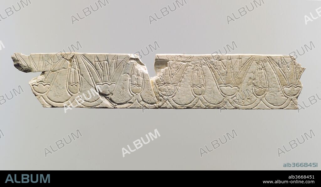 Incised furniture plaque with a frieze of lotus blossoms and buds. Culture: Assyrian. Dimensions: 1.26 x 6.73 x 0.16 in. (3.2 x 17.09 x 0.41 cm). Date: ca. 9th-8th century B.C..
This narrow, rectangular plaque is incised with a frieze of alternating lotus blossoms and buds, joined by stems. It was found in a large storeroom at Fort Shalmaneser, a royal building at Nimrud that was used to store booty and tribute collected by the Assyrians while on military campaign. Traces of light yellow paint are preserved on the buds and blossoms. The reverse of this piece has been roughened, probably to help secure the adhesive used to glue it to a frame. The frame was then probably inlaid as decoration into a piece of wooden furniture. This stylized floral frieze is similar to motifs on the large reliefs that lined the walls of the Assyrian palaces. Lotus flower and bud borders were depicted in the form of embroidery on the robes worn by the figures in the palace reliefs, and as carpet fringes, as on this stone threshold pavement slab carved to resemble a carpet, also in the Metropolitan Museum's collection (MMA X.153). Because they share motifs and images with Assyrian palace reliefs, ivories with incised decoration like this one have been attributed to an Assyrian style.
Built by the Assyrian king Ashurnasirpal II, the palaces and storerooms of Nimrud housed thousands of pieces of carved ivory. Most of the ivories served as furniture inlays or small precious objects such as boxes. While some of them were carved in the same style as the large Assyrian reliefs lining the walls of the Northwest Palace, the majority of the ivories display images and styles related to the arts of North Syria and the Phoenician city-states. Phoenician style ivories are distinguished by their use of imagery related to Egyptian art, such as sphinxes and figures wearing pharaonic crowns, and the use of elaborate carving techniques such as openwork and colored glass inlay. North Syrian style ivories tend to depict stockier figures in more dynamic compositions, carved as solid plaques with fewer added decorative elements. However, some pieces do not fit easily into any of these three styles. Most of the ivories were probably collected by the Assyrian kings as tribute from vassal states, and as booty from conquered enemies, while some may have been manufactured in workshops at Nimrud. The ivory tusks that provided the raw material for these objects were almost certainly from African elephants, imported from lands south of Egypt, although elephants did inhabit several river valleys in Syria until they were hunted to extinction by the end of the eighth century B.C.