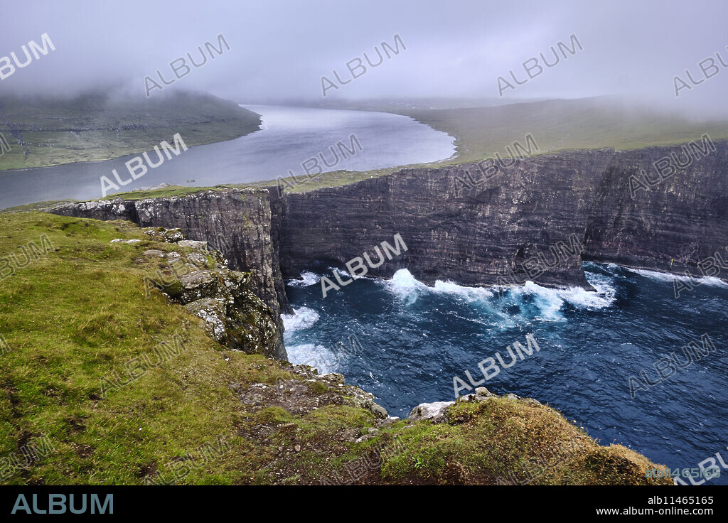 Cliffs of Traelanipa with the lake above the ocean, Faroe Islands, Denmark, Europe.