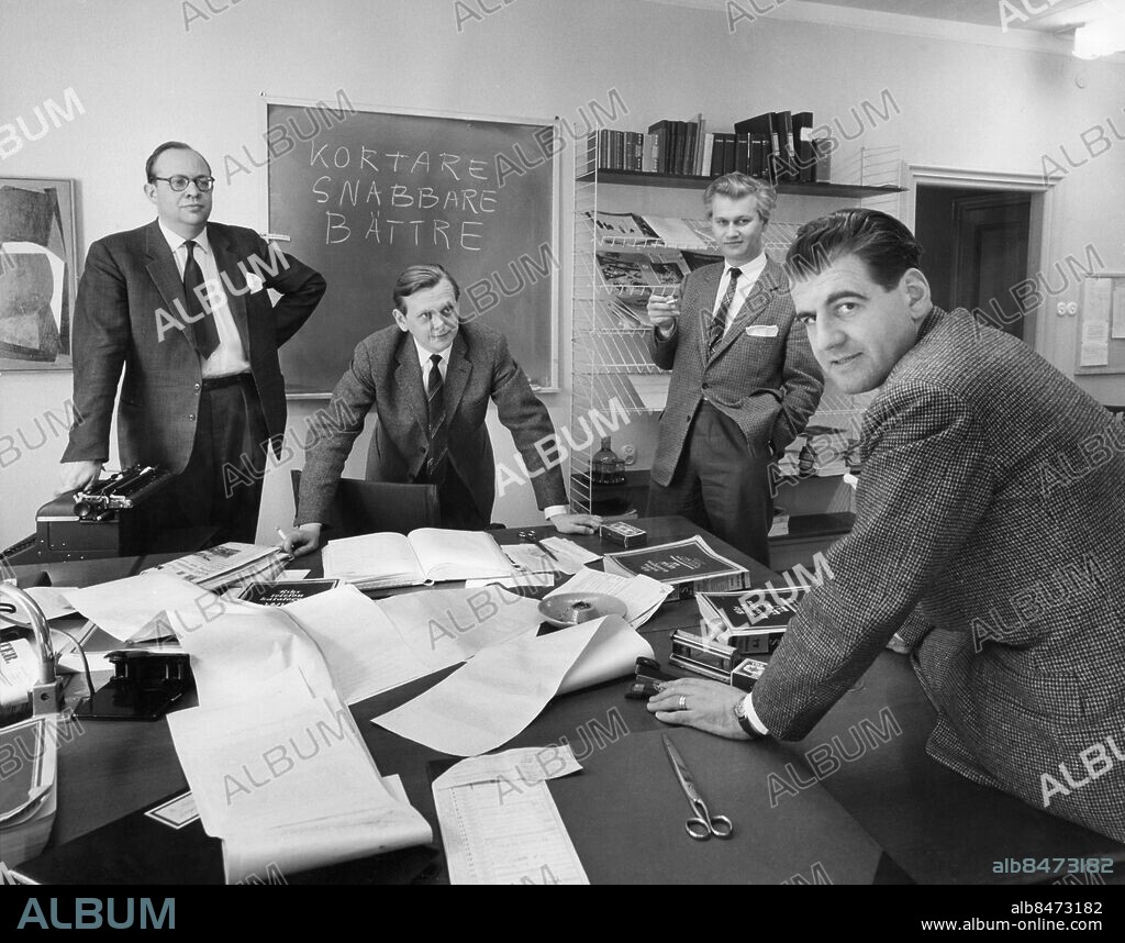 Orig. bildtext... Radiotjänstemän i Dagens Eko. Per Pehrsson, redaktör, Bo Holmqvist, Lars Ramsten, Berndt Friberg Not. fr.v. Lars Ramsten, Berndt Friberg, Bo Holmqvist och Per Persson Anm. Sveriges Radio Journalister Skivbord Möten Samtal Planering Bokhyllor Griffeltavlor Handen i fickan Kortare Snabbare Bättre Rubriker Svarta tavlan Stringhyllor CD 503 persons: PER PEHRSSON;BO HOLMQVIST;LARS RAMSTEN;BERNDT FRIBERG sites: SVERIGE;STOCKHOLM.