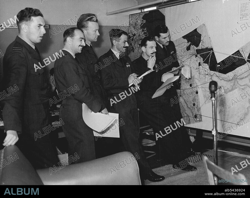 Under Starters Orders -- RAF Fliers who are taking part in the race are here seen in the briefing room at London Airport today. (Left to right) Flt. Lt. J.W. Harper of Sunderland., of Middlesex, Sqd. Ldr. L. Press of Kent., Sqd. Ldr. R. Currie of Manchester and Flt. Lt. R.M. Furze, of Herts. Lined up under starters orders, entrants for the London- New Zealand air-force were on show to the public at London Airport today. Although the instruments have been sealed in readiness for the race which st.