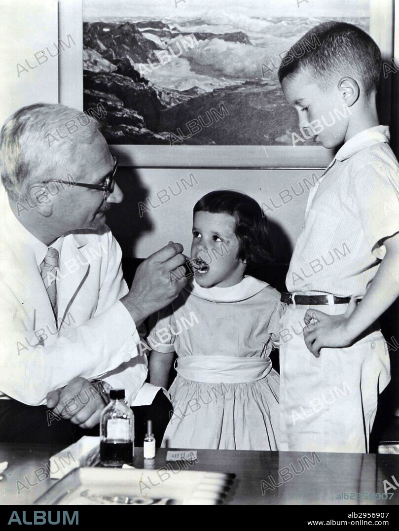Photograph of Albert Bruce Sabin (1906-1993) a Jewish Polish American medical researcher best known for having developed an oral polio vaccine. Dr Albert Sabin is seen here administering Oral Polio virus vaccine to two children. Dated 1966.