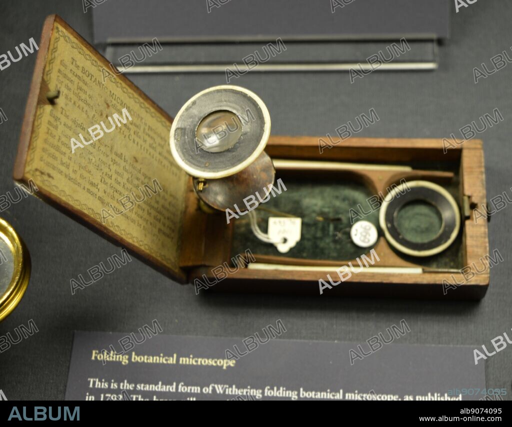 Folding botanical microscope. Standard form of Withering folding botanical microscope, published 1792. The brass pillar set in the hinge stands up when the box is opened and the upper part of the pillar screws for find focusing. The accessories are two dissecting tools and a hand magnifier.