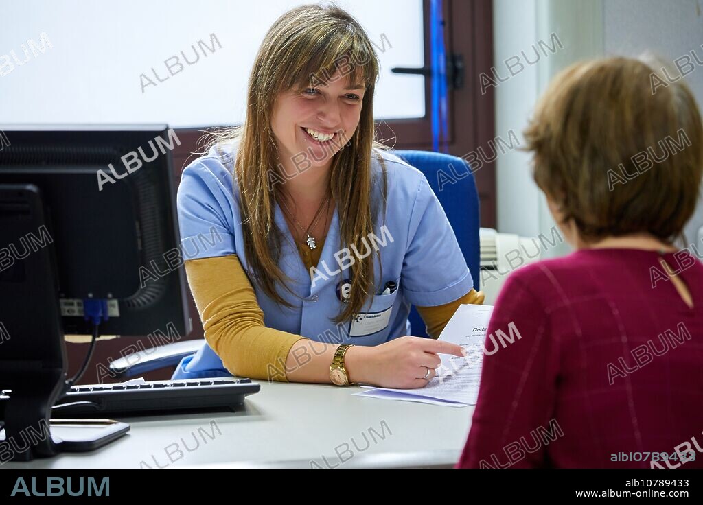 Nurse passing consultation with a patient, Antiguo Health Center, Donostia, San Sebastian, Gipuzkoa, Basque Country, SpainConsulta enfermería, Ambulatorio Antiguo, Centro de Salud, Osakidetza, Donostia, San Sebastian, Gipuzkoa, Basque Country.