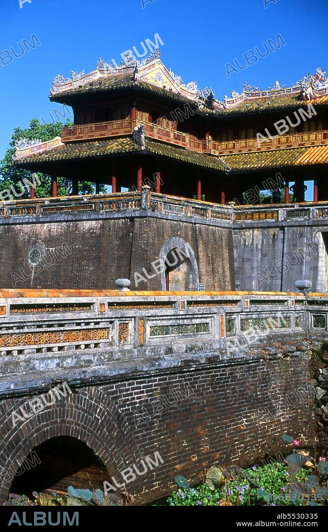The Ng? Môn (Chinese character: ??), also known as the Gate of Noon, is the main gate to the Imperial City, Hu?, located within the citadel of Hu?. It was built in 1833 in the traditional Vietnamese Nguyen style under the rule of Emperor Minh Mang. Emperor Gia Long ordered the construction of Hue Citadel in 1805. The vast complex is built according to the notions of fengshui or Chinese geomancy, but following the military principles of the noted 18th century French military architect Sebastien de Vauban. The result is an unusual and elegant hybrid, a Chinese-style Imperial City carefully aligned with surrounding hills, islands and waterways, but defended by massive brick walls between 6-12 metres high and 2.5 metres thick, punctuated by towers, ramparts, a massive earth glacis, and 24 Vauban-inspired bastions. The entire complex was further protected by wide moats, crossed by gracefully arched stone bridges leading to ten gates, the chief of which is Cua Ngo Mon, the south-east facing ‘Meridian Gate’. To compound the exotic hybrid effect, guard posts designed as Chinese-style miradors, complete with sweeping eaves crowned by imperial dragons, surmounted each gate. Finally, directly in front of the Ngo Mon Gate, a massive brick fort 18 metres high was constructed both as an additional barrier against malign spirits, and as a defensive redoubt. The area within the Citadel - in all, 520 hectares (1300 acres) - comprises three concentric enclosures, the Civic, Imperial and Forbidden Purple Cities. Access is by way of ten fortified gates, each of which is reached by a low, arched stone bridge across the moat. In imperial times a cannon would sound at 5am and 9pm to mark the opening and closing of the gates. Hue was the imperial capital of the Nguyen Dynasty between 1802 and 1945. The tombs of several emperors lie in and around the city and along the Perfume River. Hue is a UNESCO World Heritage Site.