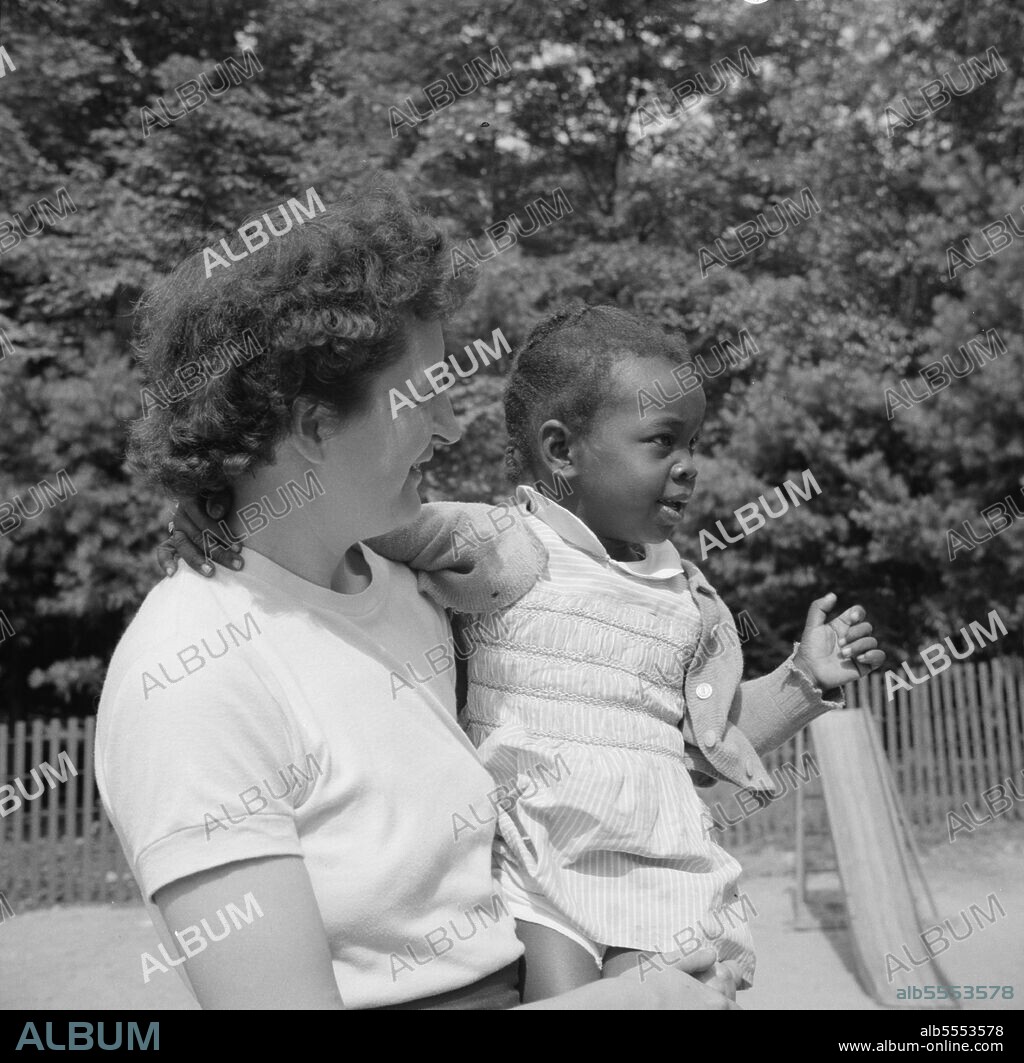 GORDON PARKS. Arden, New York. Interracial activities at Camp Ellen Marvin, where children are aided by the Methodist Camp Service. Mrs. Janet P. Murray, Director of Ellen Marvin and Gaylord White Camps, holding one of the nursery school campers.