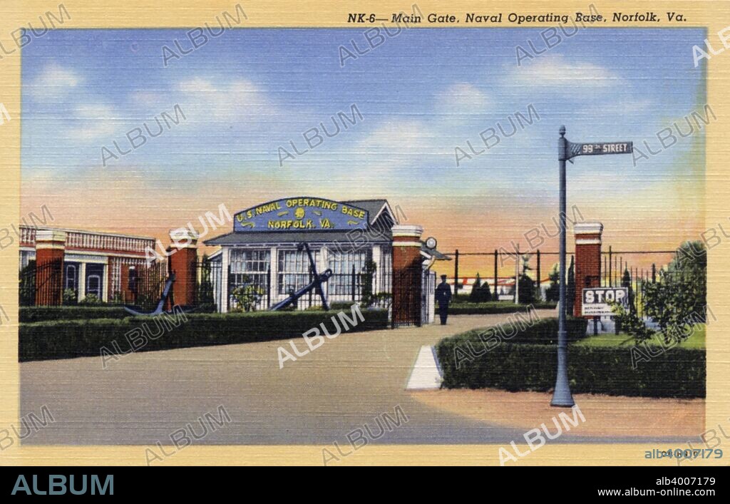 Main gate, Naval Operating Base, Norfolk, Virginia, USA, 1940. Postcard. The red brick guardhouse and gate is visible. A guard is on duty. The naval base at Norfolk is the largest in the world.