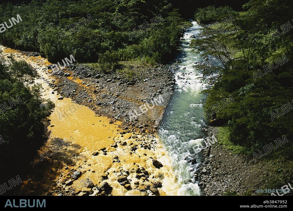The Rio Sucio, tinted brown by the Irazu Volcano, meets a clear mountain stream in Costa Rica.