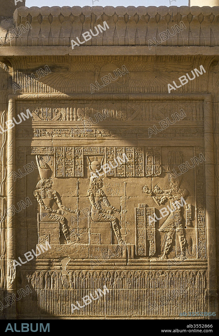 Egypt, Philae. Reliefs on a wall of the Temple of Isis. Offering scene to the god Horus (falcon-headed) and goddess Isis (solar dish). Lower strip representing lotus flowers.