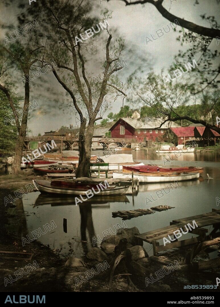 ARKIV 1932. Färgbild från Pålsundet i Stockholm. På andra sidan vattnet syns Långholmen.. Den första svenska färgbilden, ett kvinnoporträtt publicerades i Svensk Fototidskrift 1903. De första autochrome-plåtarna som användes till den här bilden kom till Sverige 1906 och fick en snabb spridning men det var först 1935-1936 med lanseringen av Kodachrome och Agfacolor-Neu-filmerna som föutsättningen för en bred utveckling skapades.. Denna bild är tagen 1932.. Colourpicture from the channel Pålsundet in Stockholm. Opposite the water is island Långholmen.. Foto: TT Historical/1900. Scanpix Sweden.