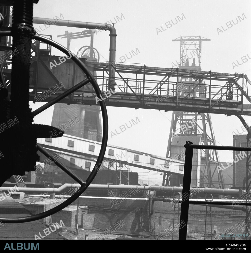 Manvers Main Colliery, Wath upon Dearne, near Rotherham, South Yorkshire, 1963. Taken for a cover image for the NCB Coal Quarterly Magazine, the photograph shows the head gear at the colliery. Manvers was sunk on land belonging to Earl Manvers in in the late 1800s and this was followed by the second shaft, sunk between 1900 and 1901. A third shaft was added later. Manvers was the regional headquarters for British Coal and the also housed laboratories. The site also included the Manvers coking plant which was at the time the largest industrial site in Europe. The coking works closed in 1981 with the colliery closure following a few years later on 25th March 1988.