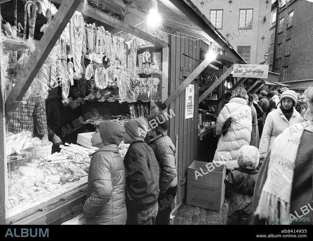 Stockholm 1983-11-26. Julmarknad på stortorget i Gamla stan. Trots att det var sju grader varmt, slaskigt på gatorna och dimman och regnmolnen hängde som en våt disktrasa över Stockholm, startade julen på lördagen. PåStortorget i Gamla stan var det helsvenskt med hantverk från Gotland och spettekakor i Skåne.. Foto: Arne Jönsson / DN / TT / Kod: 35. ** SvD OUT **.