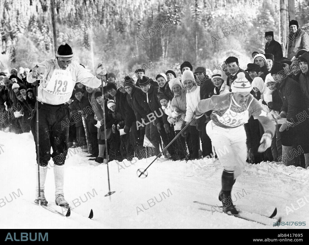 1963-01-07. Norges skidkung, Harald Grönningen, har åkts i fatt av Assar Rönnlund och blir passerad just på mållinjen. Assar hade bråttom. Det gällde sekunder för honom i kampen med Ragnar "Föllinge" Persson och Sixten Jernberg. Han vann kampen med god marginal.. Foto: Olle Seijbold / DN / TT / Kod: 51. ** SvD OUT **.