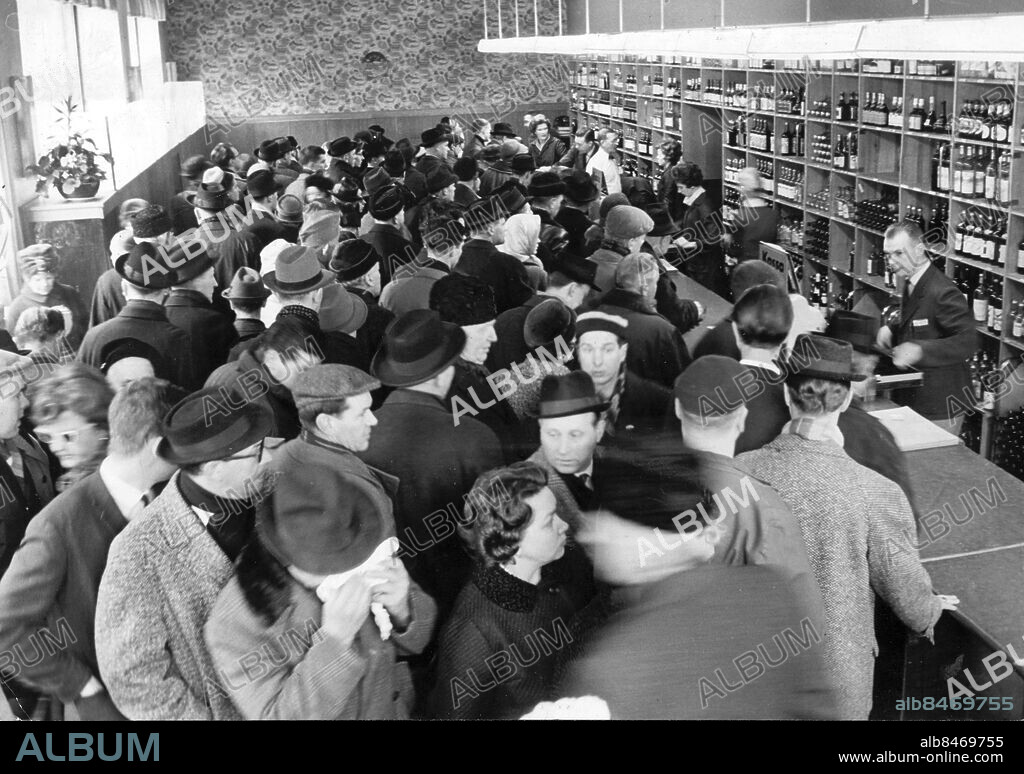 Stockholm 1963-03-01. Spritbrist på grund av strejken på Vin- & Spritcentralen, som är enda leverantör till Systembolaget. Lördagen var stora ködagen på systemaffärerna i Stockholm. Den här bilden är tagen minuterna strax efter kl 9 då butikerna öppnades. Köerna blev sedan än större under förmiddagens lopp.. Att Vin- och Spritcentralen och så småningom även systembutikerna kan få slå igen är en logisk följd av strejken. Utan arbetsledare sker ingen ny framställning eller tappning av sprit, varför heller inga nya leveranser kan ske till de olika ut-minuteringsställena.. Foto: Olle Wester / Expressen / TT / Kod: 44. ** AFTONBLADET OUT **.