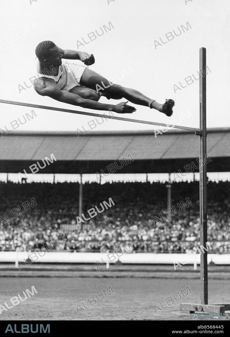 Orig. bildtext... U.S.A. WINS THE HIGH JUMP (Aug.2nd, 1937) C.C. JOHNSON (U.S.A.) wins the high jump at the White City to-day, clearing 6ft.5ins. Anm. Johnson, Cornelius Cooper, 1913-46, amerikansk idrottsman, höjdhoppare Arenor Ribbor Kaliforniska stilen Prestationer Kraftutveckling Idrottsmän CD380 persons: CORNELIUS COOPER JOHNSON sites: USA*;STORBRITANNIEN;LONDON.