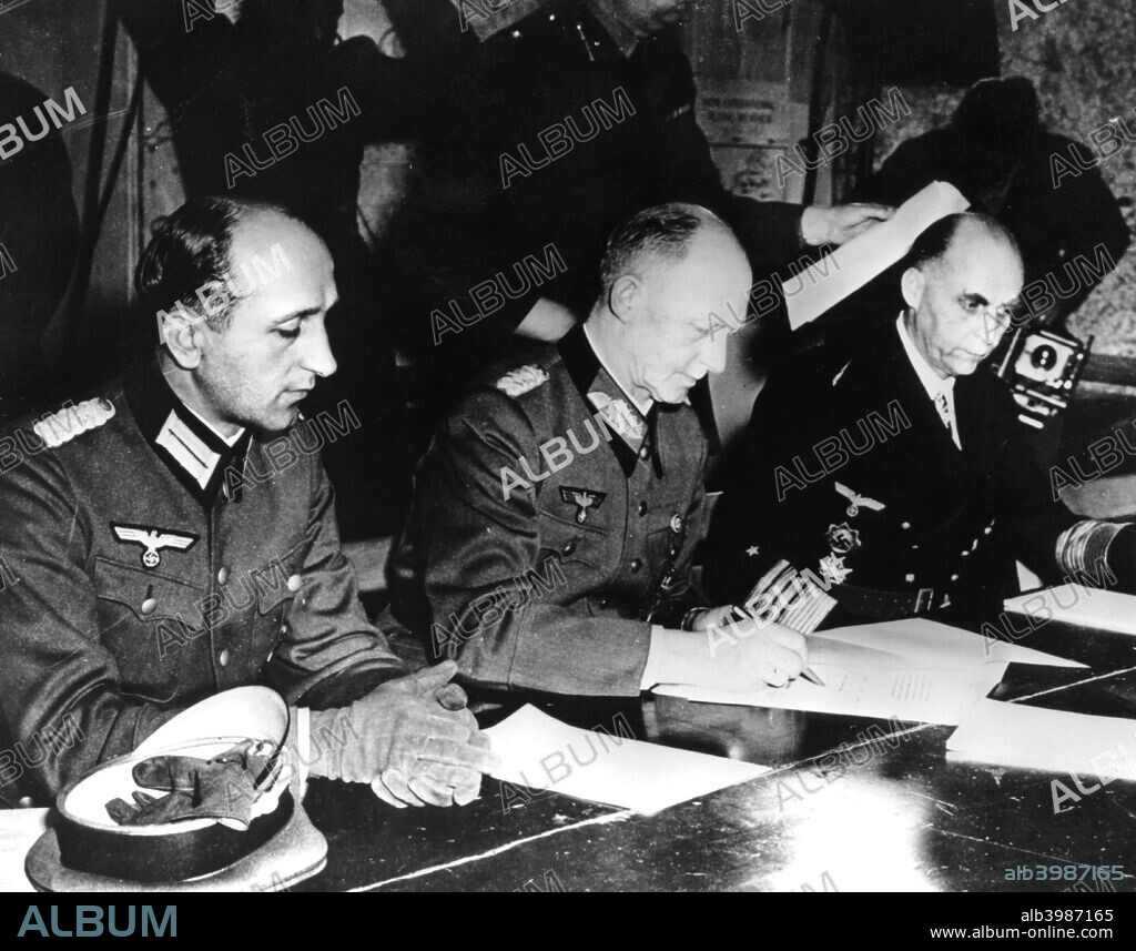 Surrender of Nazi Germany, Reims, France, 7 May 1945. General Alfred Jodl, the German Chief of Staff signing the document confirming Germany's unconditional surrender to the Allies. He is flanked by his aide Major Wilhelm Oxenius (left) and Admiral Hans Georg von Friedeburg, commander of the German Navy.
