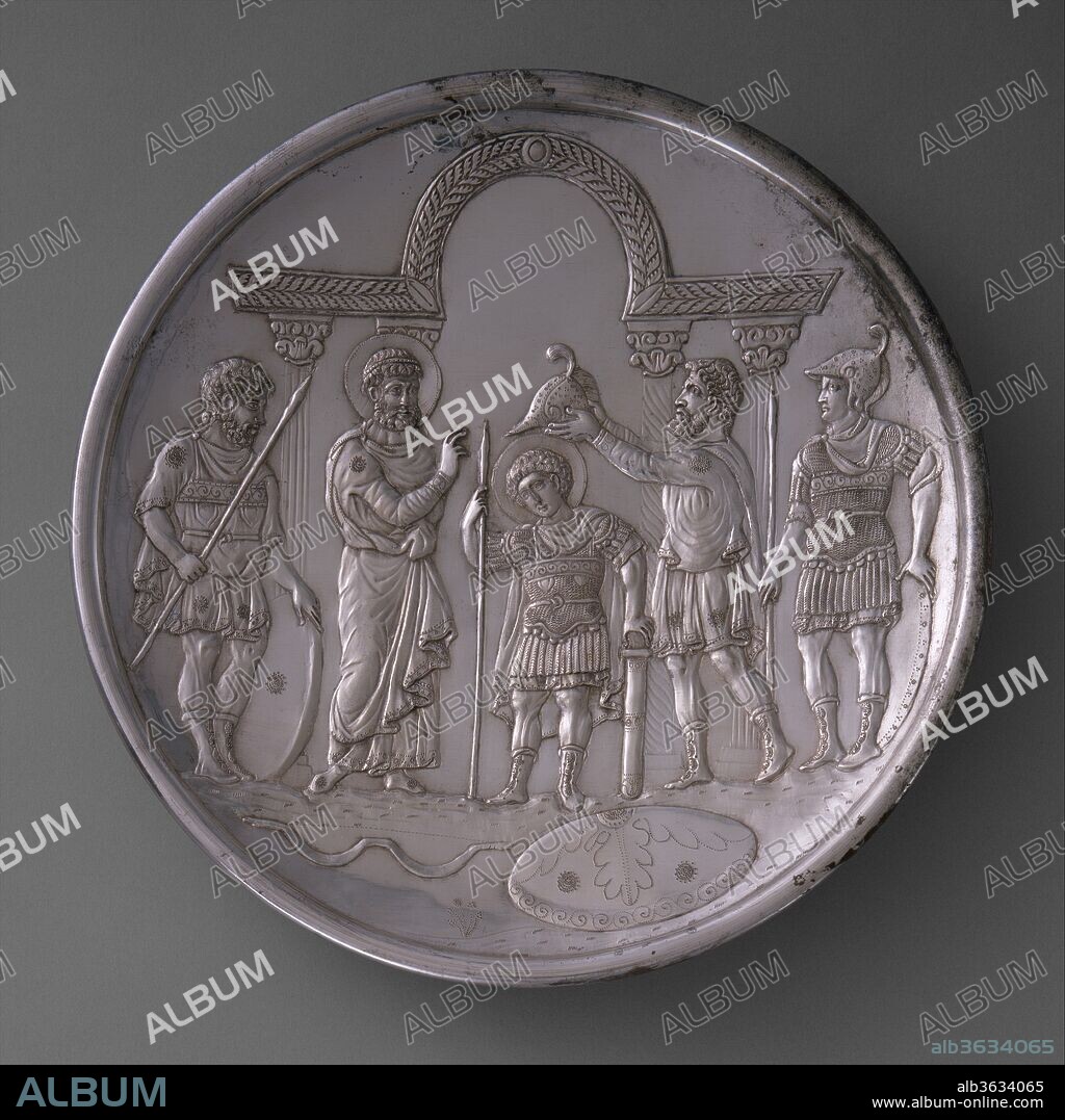 Plate with the Arming of David. Culture: Byzantine. Dimensions: Overall: 10 1/2 x 1 9/16 in., 49.3oz. (26.6 x 4 cm, 1397g)
foot: 4 9/16 x 9/16 in. (11.6 x 1.4 cm). Date: 629-630.
In 628-29 the Byzantine emperor Herakleios (r. 610-41) successfully ended a long, costly war with Persia and regained Jerusalem, Egypt, and other Byzantine territory. Silver stamps dating to 613-29/30 on the reverse of these masterpieces place their manufacture in Herakleios's reign. The biblical figures on the plates wear the costume of the early Byzantine court, suggesting to the viewer that, like Saul and David, the Byzantine emperor was a ruler chosen by God. Elaborate dishes used for display at banquets were common in the late Roman and early Byzantine world; generally decorated with classical themes, these objects conveyed wealth, social status, and learning. This set of silver plates may be the earliest surviving example of the use of biblical scenes for such displays. Their intended arrangement may have closely followed the biblical order of the events, and their display may have conformed to the shape of a Christogram, or monogram for the name of Christ.
David is shown receiving Saul's armor for his battle with Goliath (1 Samuel 17:38). He stands under an arcuated lintel. In late Roman and early Byzantine art, this architectural structure, suggesting a palace, was used to distinguish the emperor and here implies David's future role as king. The armor is Roman, a metal breastplate over a short tunic. To David's right is Saul, who wears a chlamys, or cloak, over a short-sleeved tunic, which covers another tunic with embroidered cuffs, a standard feature of Byzantine courtly dress.