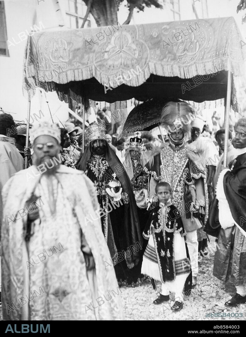 Orig. bildtext... THE CORONATION OF RAS TAFARI AS KING OF KINGS AND LION OF JUDAH, AT ADDIS ABEBA. O.P.S. The King leaving the cathedral after the coronation ceremony. He is carrying his Orb and Sceptre of authority and is wearing his wonderful jewelled crown. Anm. Ras Tafari,1892-1975, tog efter kröningen namnet Haile Sellassie I. Kejsare av Etiopien 1930-1974 Lejonet av Juda Kejsare Kröningar Ceremonier CD473 persons: MAKONNEN, PRINS AV ETIOPIEN;HAILE SELLASSIE I, KEJSARE AV ETIOPIEN sites: ETIOPIEN;ABESSINIEN;AFRIKA.