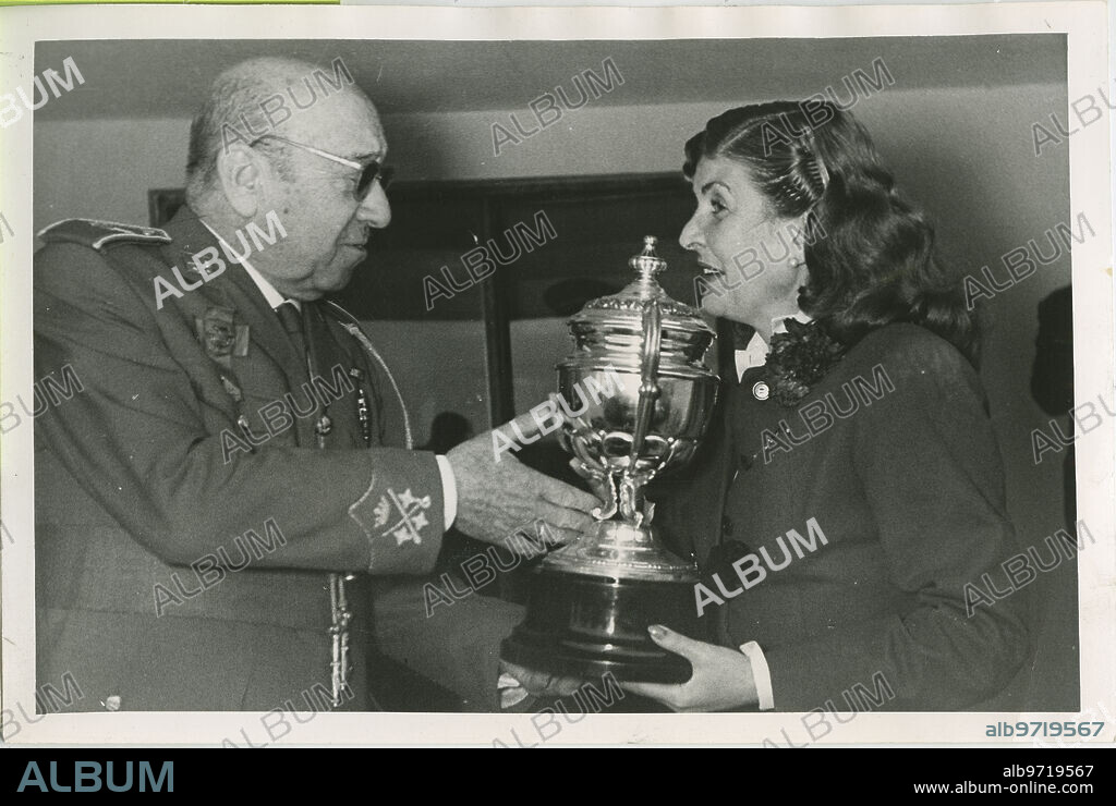 Madrid, 05/01/1955. The national sports delegate, General Moscardó, presents the Duchess of Valencia, Luisa Narváez, with the equestrian cup of the Generalísimo Grand Prix, won by "Chipirón", a horse he owns.