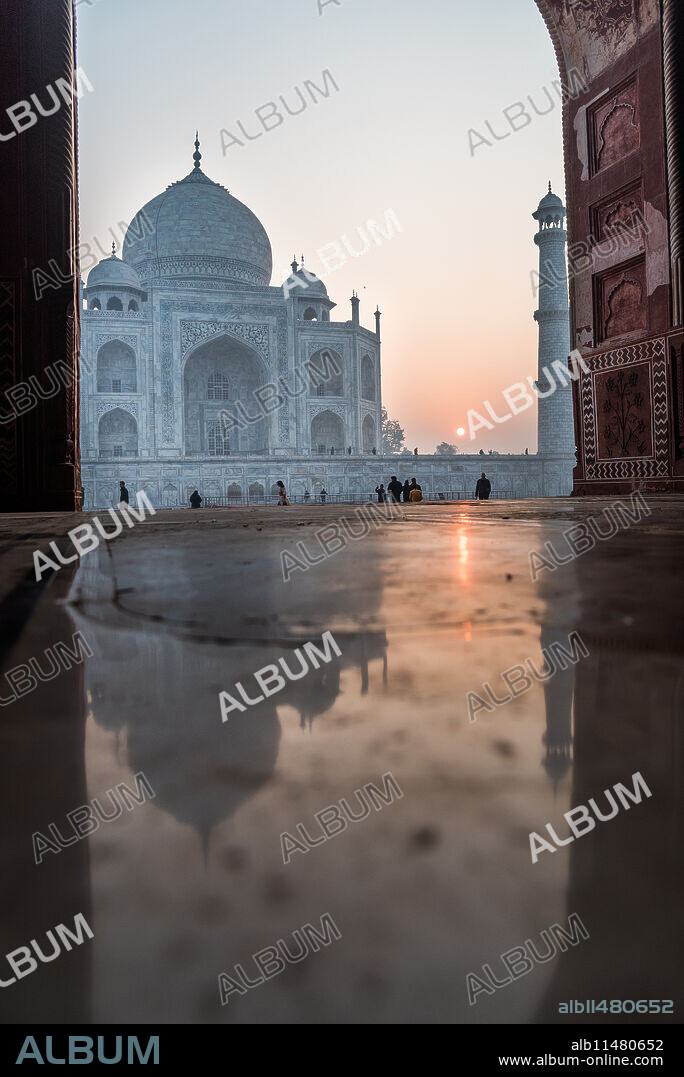 Reflections as the sun rises behind the Taj Mahal, UNESCO World Heritage Site, Agra, Uttar Pradesh, India, Asia.