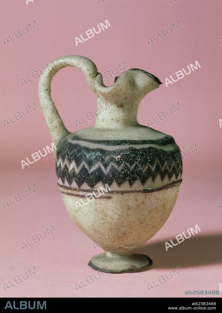 ARTE ROMANO. ESPAÑA. "URCEOLUM". Jarrita de vidrio blanco con una franja de hileras moradas. Tiene asa y un pequeño pie. Se ignora su procedencia. Museu Episcopal de Vic. Provincia de Barcelona. Comarca de Osona. Cataluña.