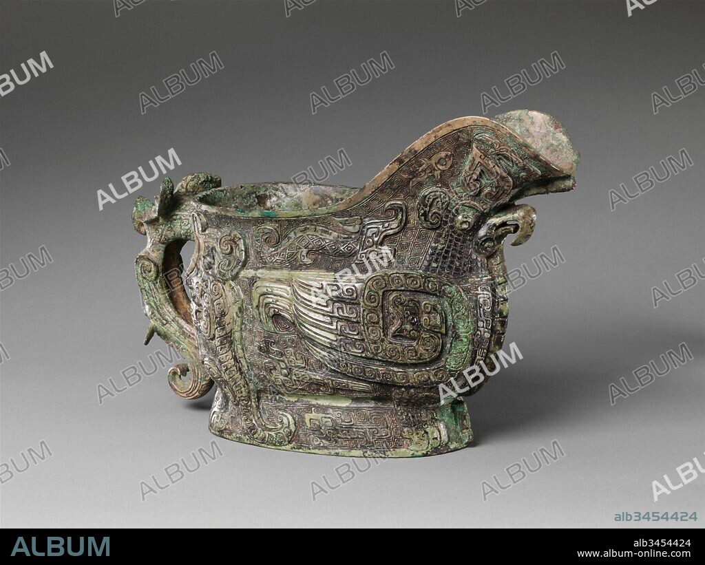 ? ???, Spouted Wine Vessel (Gong), Shang dynasty (ca. 1600–1046 B.C.), 13th century B.C., China (Henan Province, possibly Anyang), Bronze, H. 8 1/2 in. (21.6 cm), Metalwork, Every surface of this vessel is animated with fantastic creatures: an owl-like bird with coiled serpent wings dominates the body while another bird forms the handle. Felines, dragons, and fish fill the spaces in between.