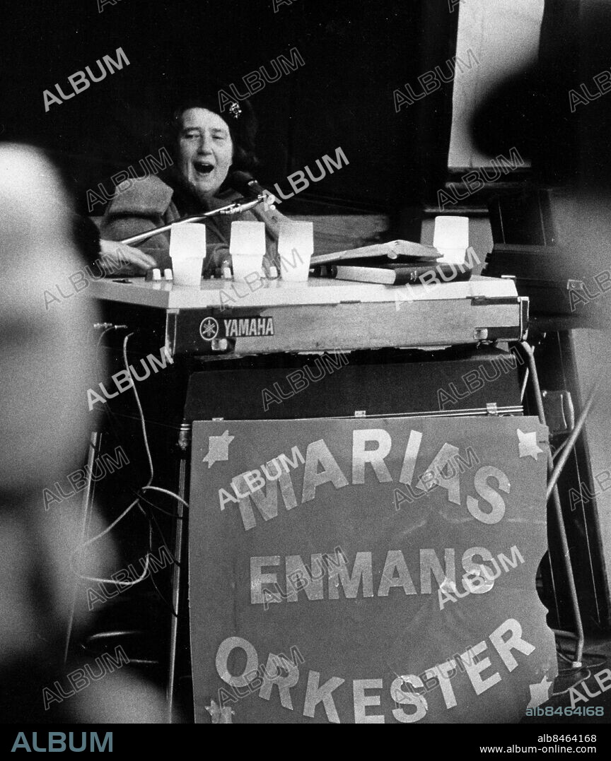 Stockholm 1974-01-13. Gatumissionären och gatumusikanten Maria Johansson sitter vid sin orgel på Sergels torg i Stockholm och sprider sitt kristna budskap genom att sjunga och spela religösa sånger.. Foto: Jan Düsing / Expressen / TT / Kod: 12. ** AFTONBLADET OUT **.