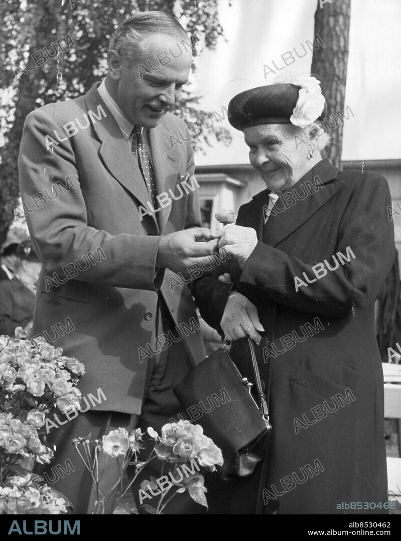 ARKIV 1950 - Intendent Ulf Engdahl plockar en ros till fru Sofia Gustavsson på Dagens Nyhers utflykt för gamla På Danviken. Foto: DEX Kod: 192 COPYRIGHT SCANPIX SWEDEN.