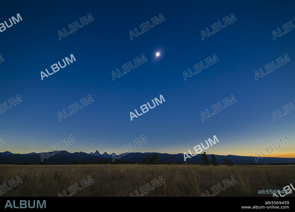August 21, 2017 - Total solar eclipse over the Grand Tetons as seen from the Teton Valley in Idaho, near Driggs. This is from a 700-frame time-lapse and is of third contact just as the second diamond ring is starting and the dark shadow of the Moon is receding to the east at left. The sky is darker to the left but the foregound is beginning to light up as the sky to the west off camera to the right brightens and lights the scene. Jupiter is just above the Tetons at bottom.