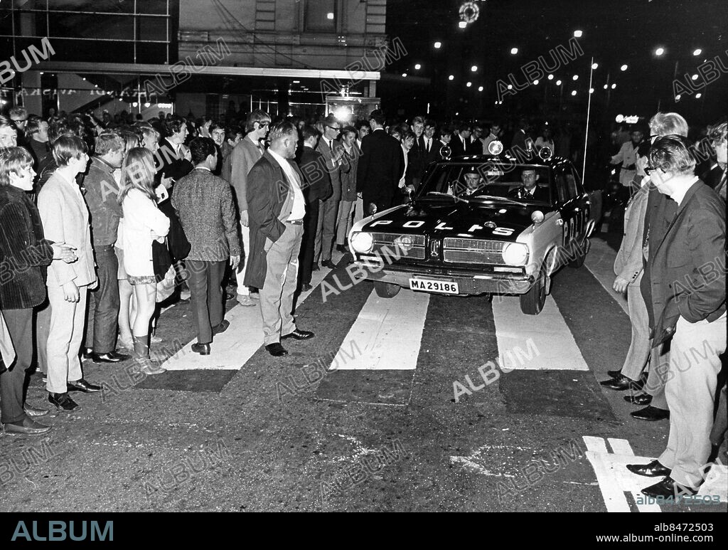 Högertrafikomläggningen övergången till högertrafik sept 1967. Polisbil på Gustav Adolfs Torg kör över till höger sida av gatan bland människor folk övergångsställe.. Foto: Staffan Johansson / Sydsvenskan / IBL.