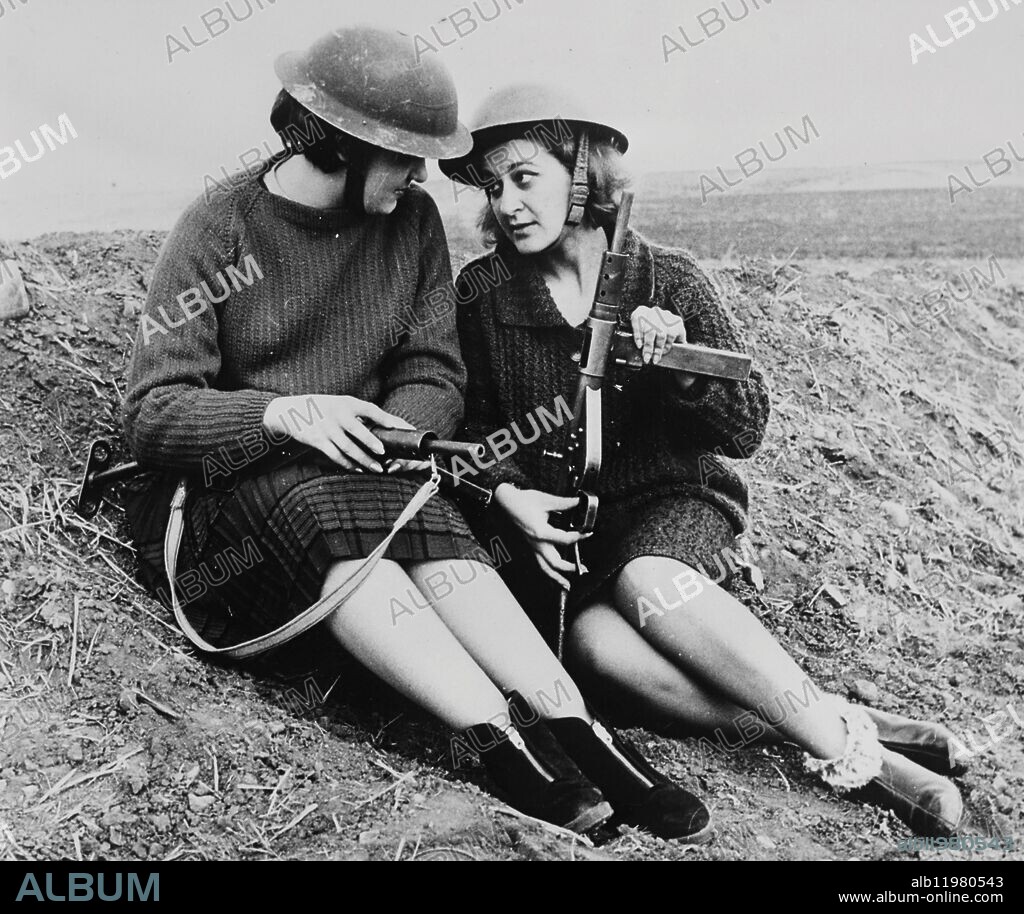 Cyprus women soldiers. Greek Cypriot girls at a training exercise near Nicosia: holding onto their sub-machine guns they find time for a chat during a break. [defence, army, civilian, women, guns, helmets, funny]. 24 February 1964.