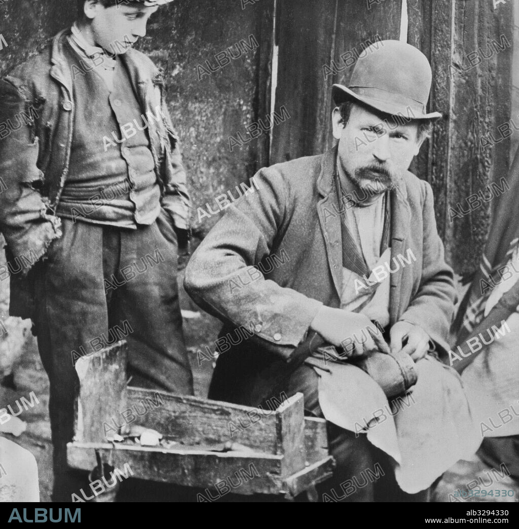 Street Cobbler Mends A Pair of Shoes. Dublin, c1895.