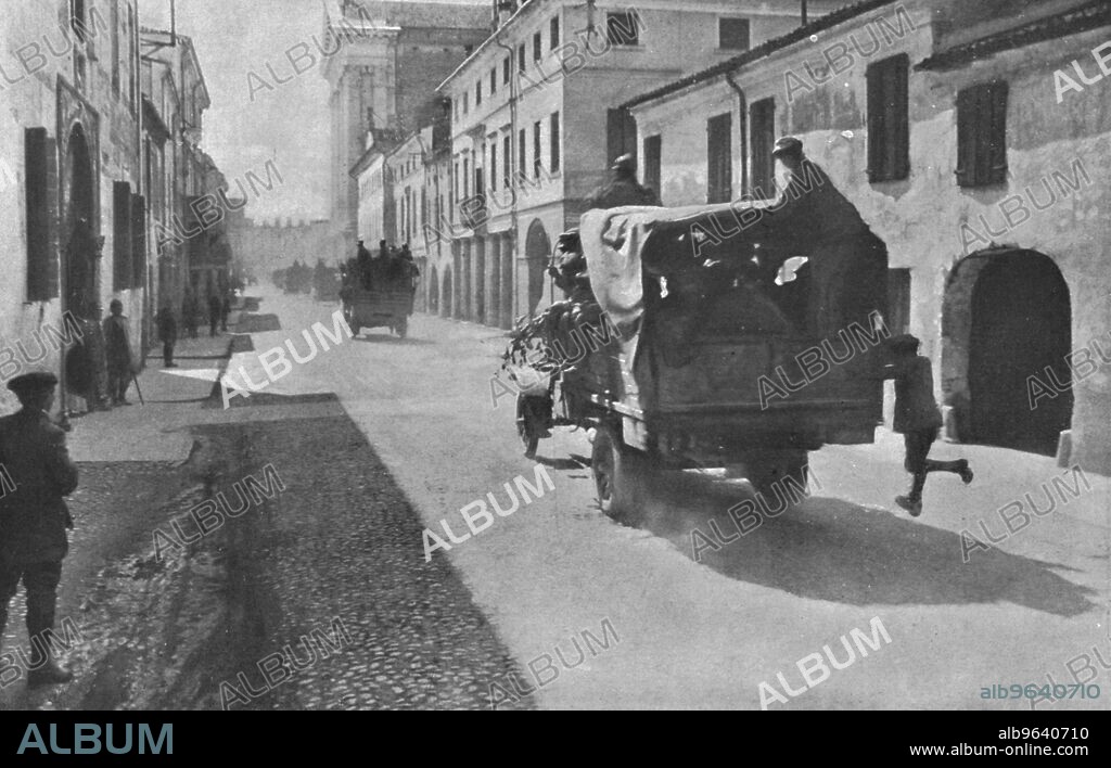 'Sur le front Italien; L'Offensive Autrichienne dans le Trentin. Zone de guerre 10 juin 1916. Comme a Verdun: camions automobiles charges de troupes, traversant une ville de la Haute-Venetie et se dirigeant vers le front de combat', 1916. From "Collection de la Guerre IV. L'Illustration Tome CXLVII. La Guerre Janvier, Fevrier, Mars, Avril, Mai, Juin 1916".